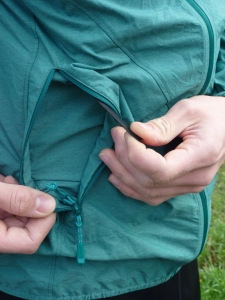Die Crag WB Hooded Jacket kann in der eigenen Seitentasche verstaut und über ein Gummiband z. B. am Klettergurt befestigt werden.