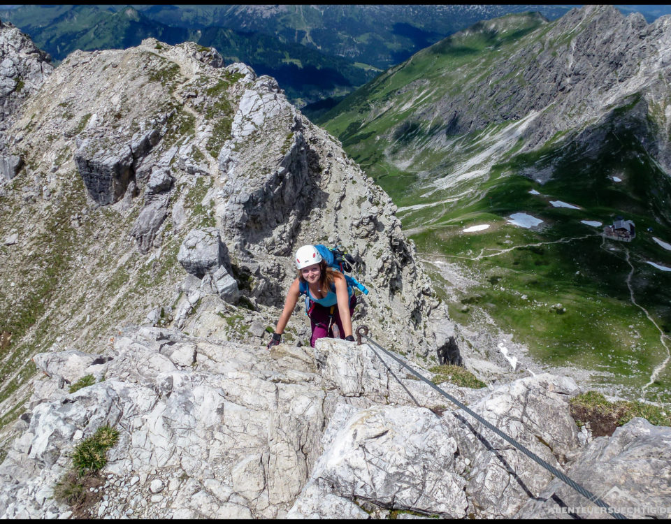 Elena unterwegs auf dem Mindelheimer Klettersteig. Im Hintergrund die Fiderepaßhütte.